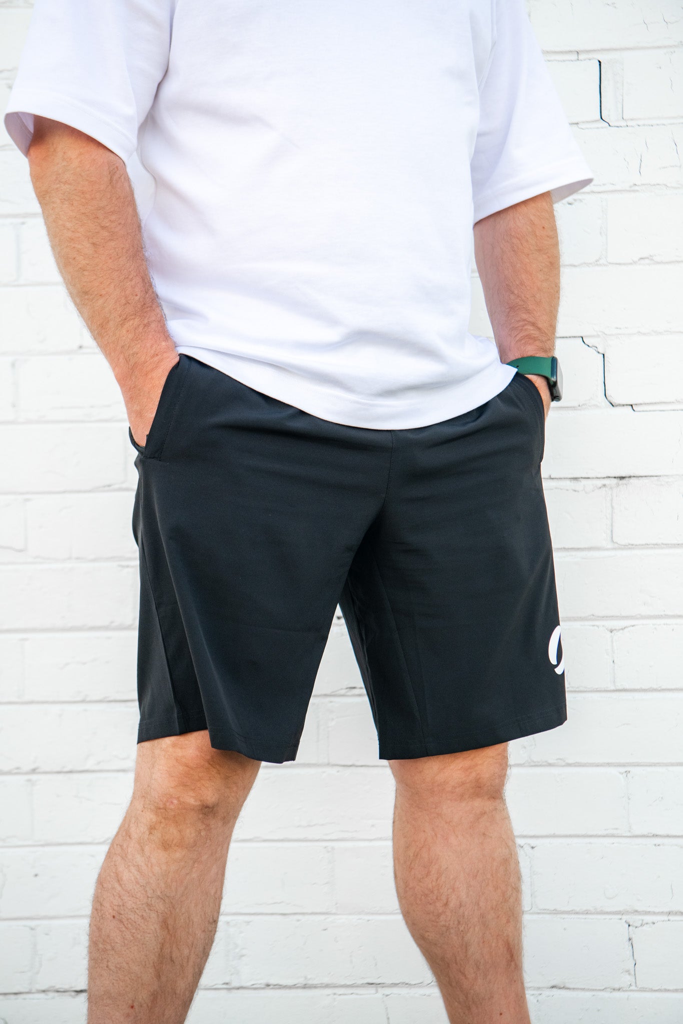 Angled view facing right of person wearing long pocket shorts facing right