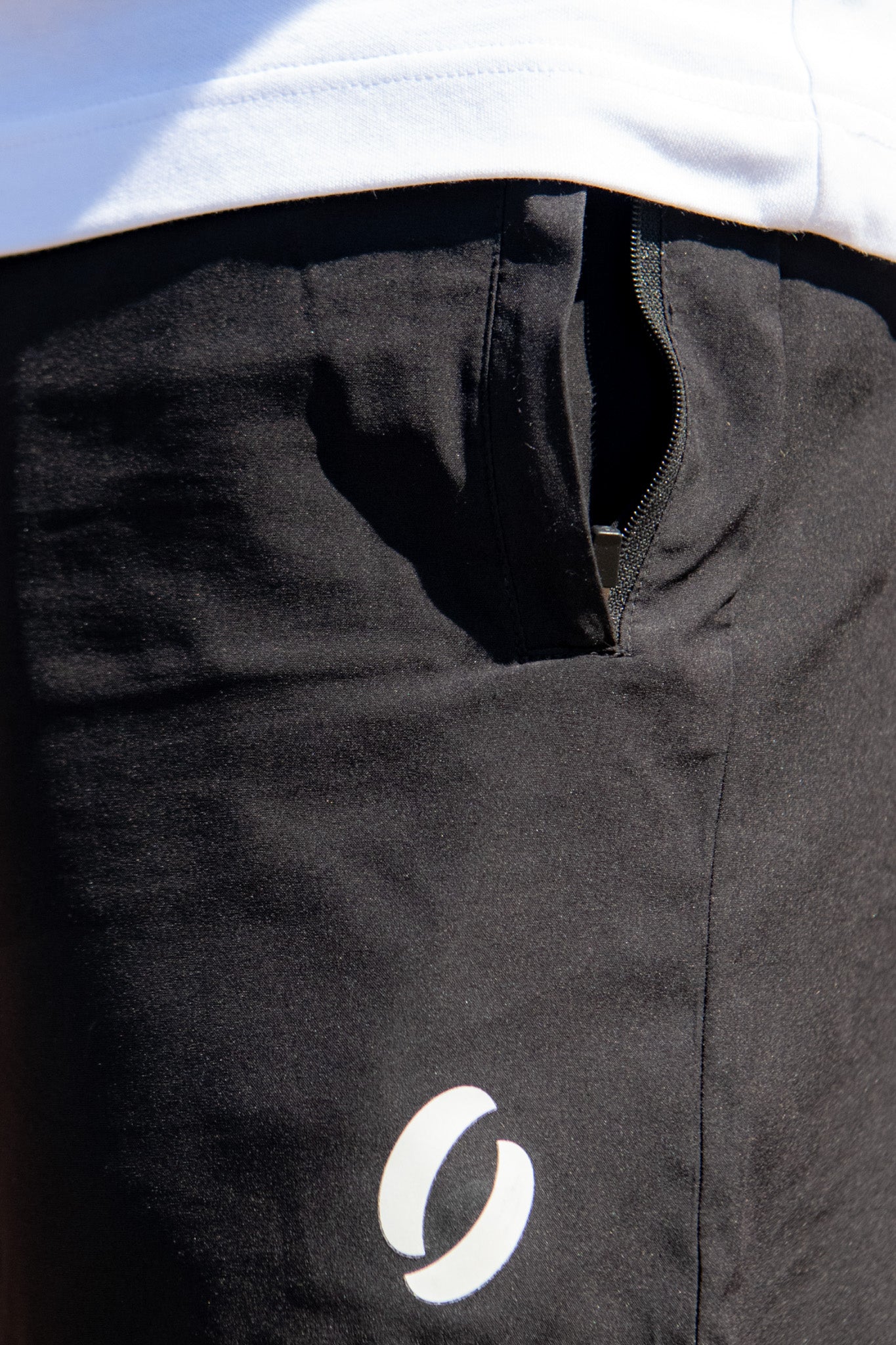 Close up view of pockets of the shorts having them zipped open