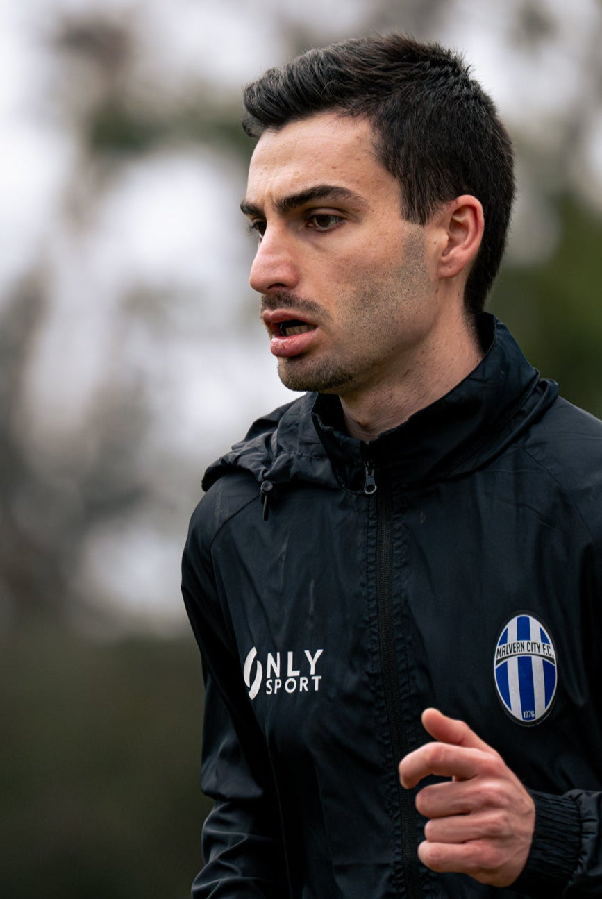 Man running outdoors wearing a black jacket