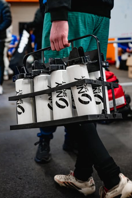 Person carrying a tray with white water bottles