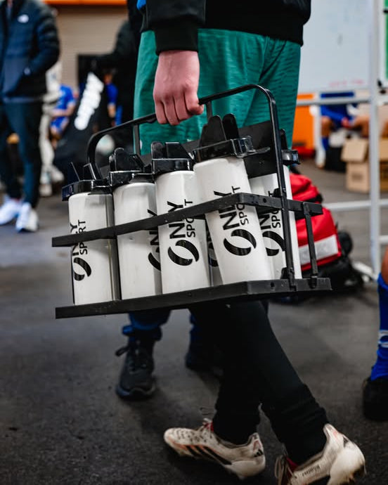 Person carrying a tray with white water bottles