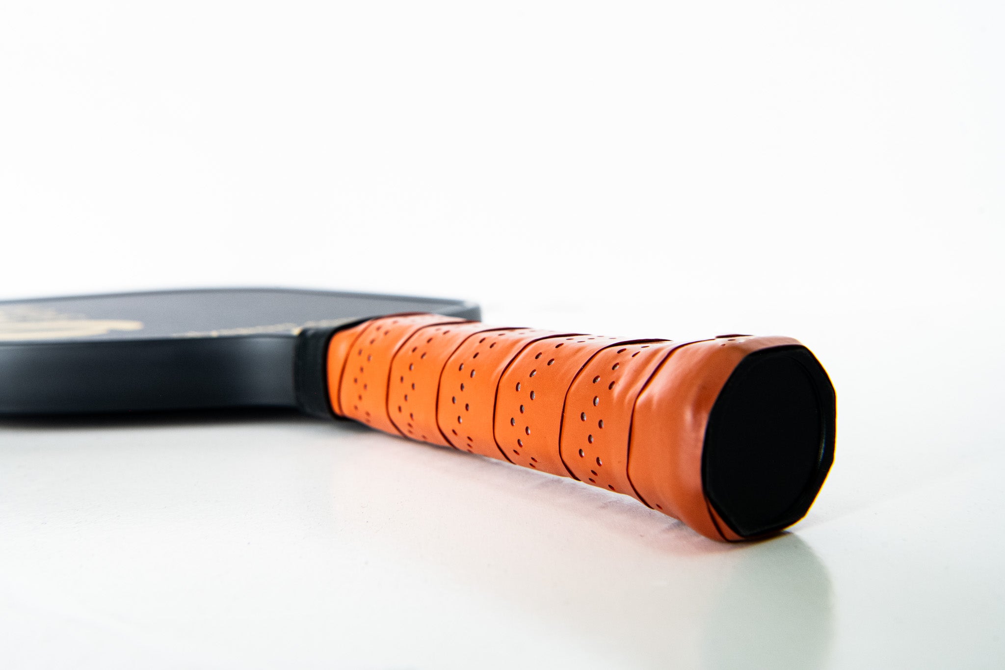 Angled view of paddle's grip and handle laying on the floor