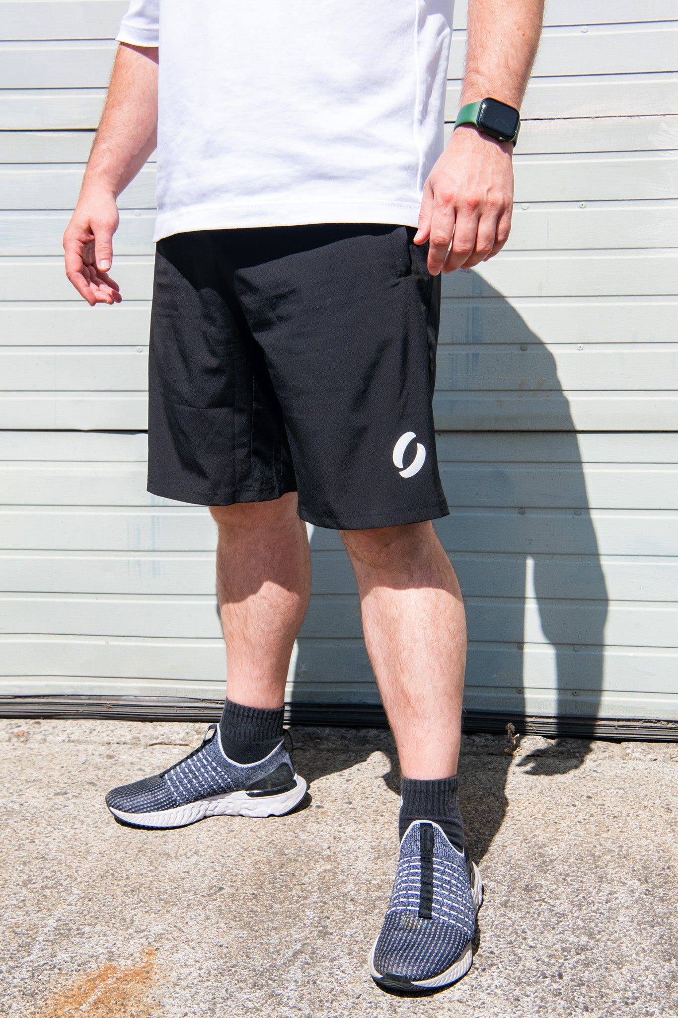 Angled view facing left of person wearing long pocket shorts