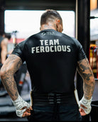 Person wearing a black 'Team Feroocious' shirt in a gym setting