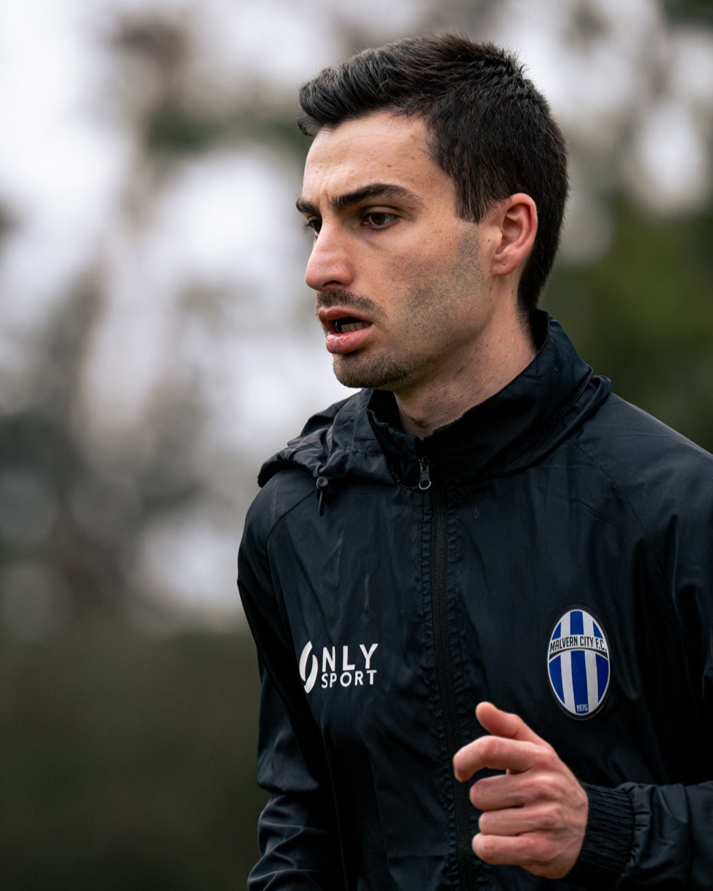 Man running outdoors wearing a black jacket 