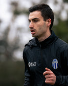 Man running outdoors wearing a black jacket 