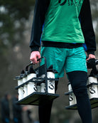 Person carrying a set of water bottles with 'ONLY SPORT' branding.