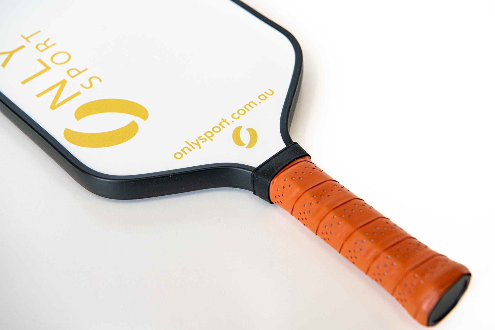 Angled view of white paddle from the top as it lays on the ground 