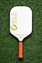 Front view of white paddle laying on the artificial turf